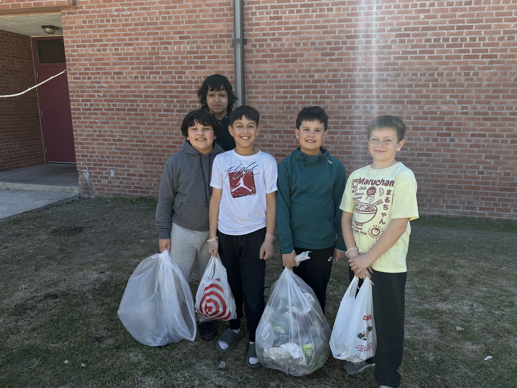 Kids outside cleaning up the school yard