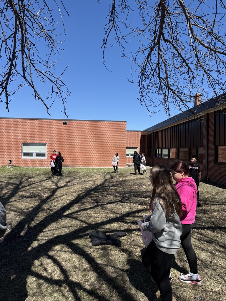Kids outside cleaning up the school yard