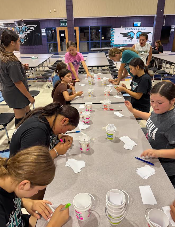 8th grade volleyball team writing positive notes to each other