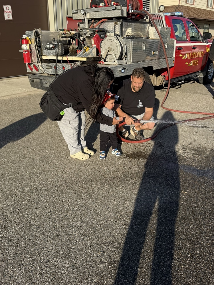 child spraying water from a fire hose