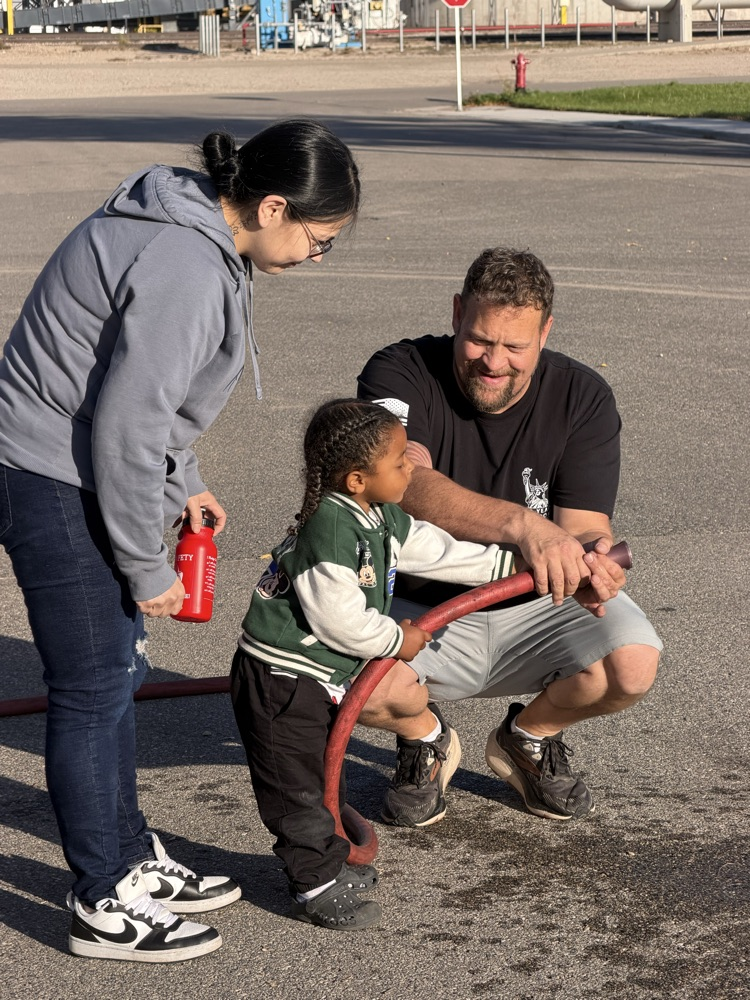 child spraying water from a fire hose