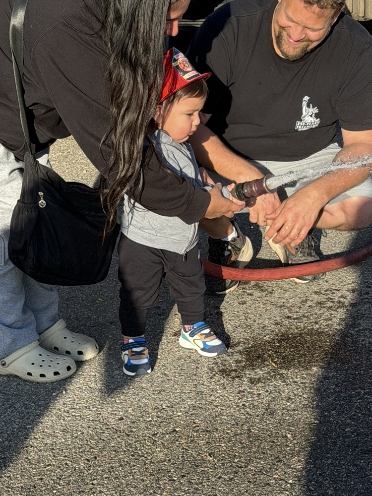 child spraying water from a fire hose