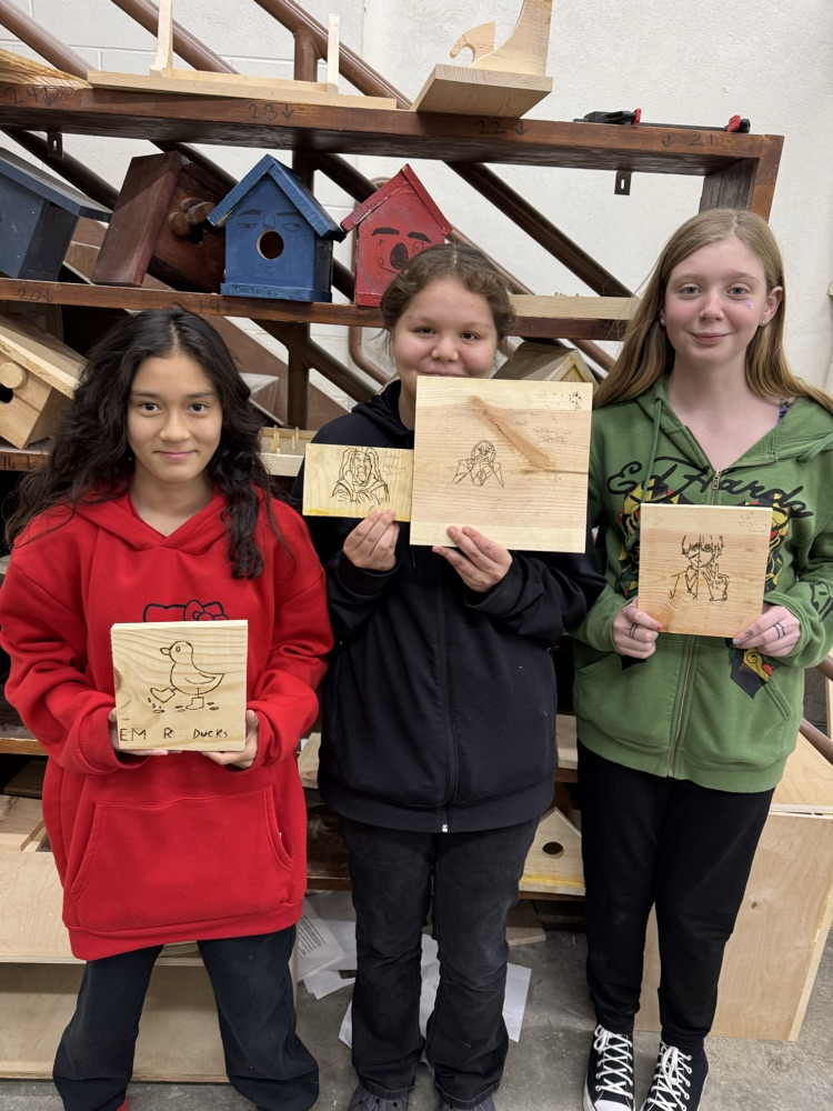 students holding wood burning projects