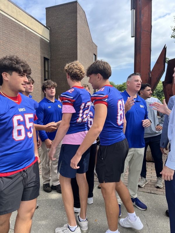 Mahopac and Carmel football players connecting during the raising of the flag at town hall