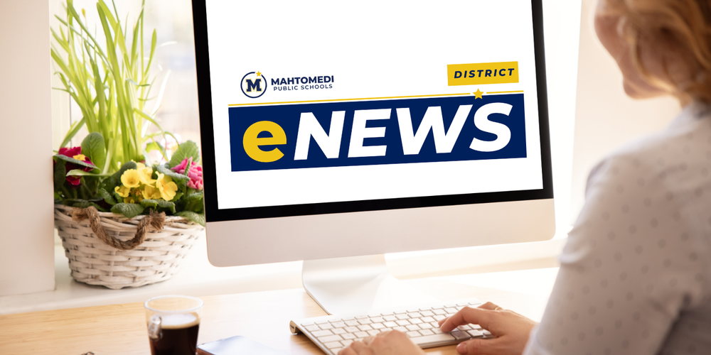 Woman at computer reading district eNews