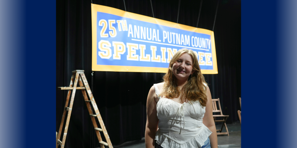 Student standing on stage of production