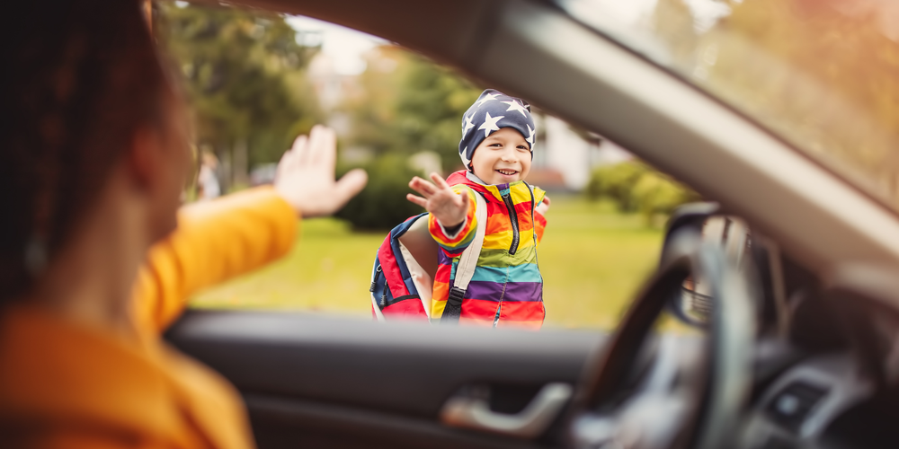 child waving to adult at school