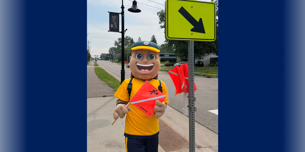 Mascot holding "See Me" Flag