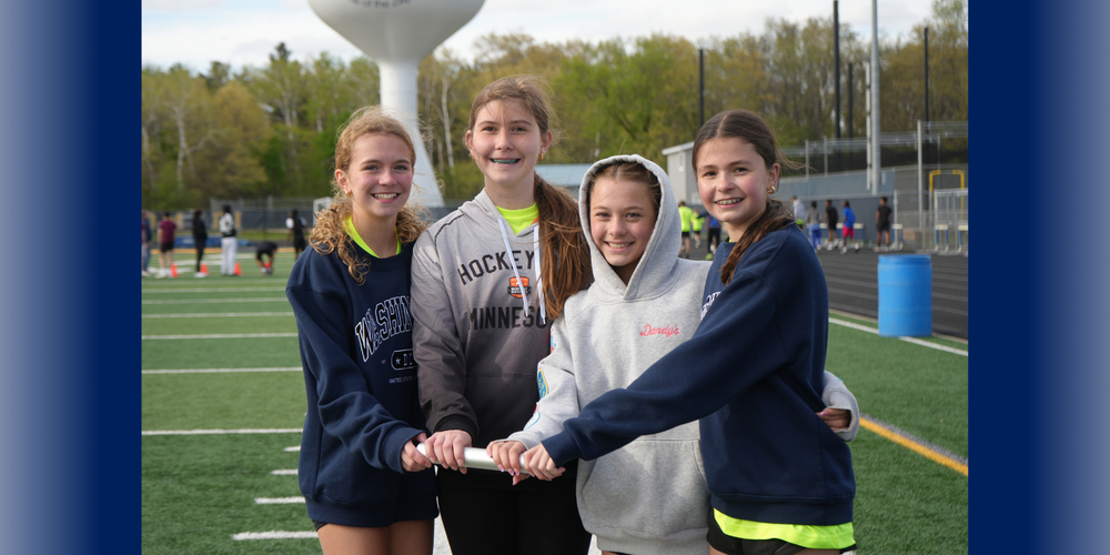 Four students in track and field holding race baton