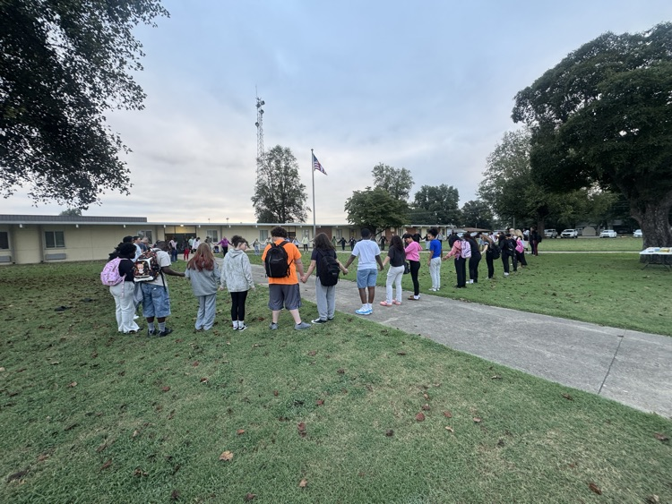 students praying around the pool