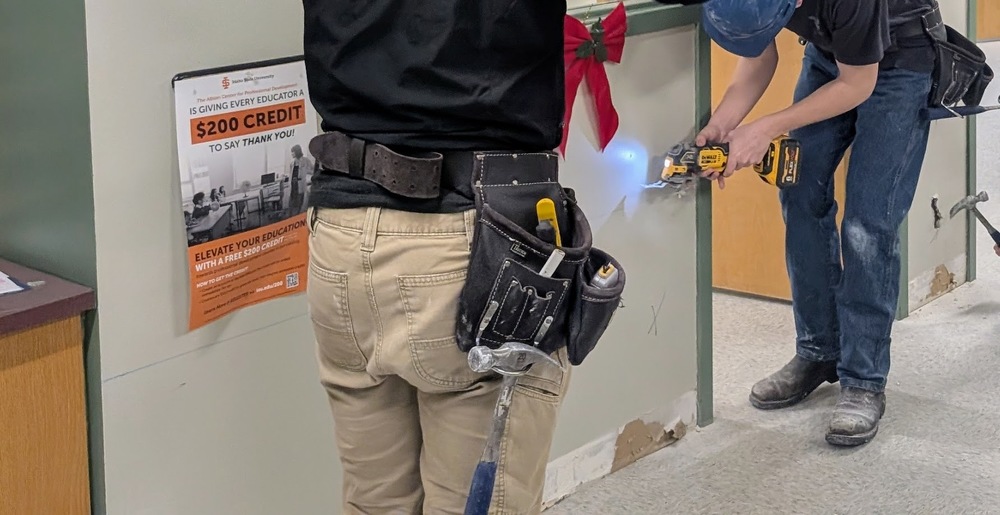 Building Trades students cutting sheetrock in the FA Main Office.