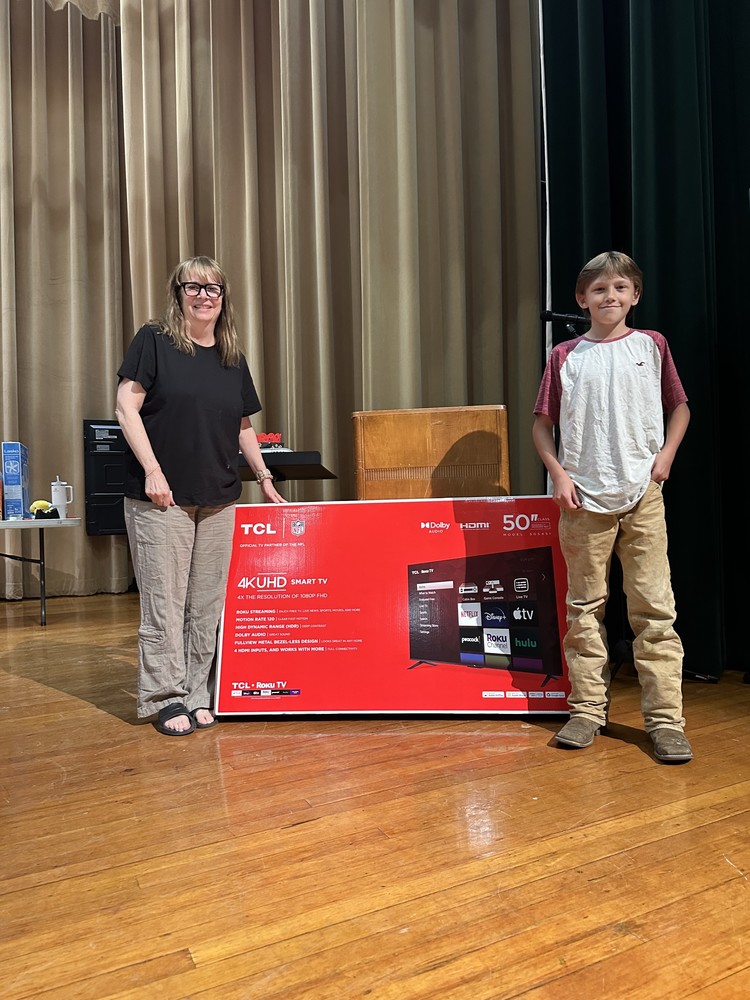 Seventh grader Trevor Boyea being presented with a big-screen TV from Mrs. Boyer during the middle school's end-of-year prize giveaway
