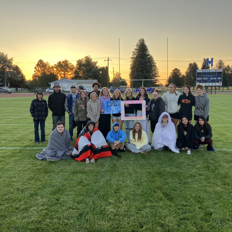 Senior class posing in front of a sunrise 