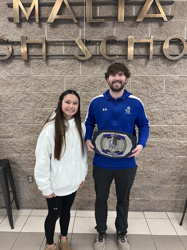 student presenting a teacher with an award. 