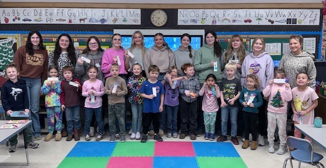 NHS members read to Mrs. Ost and Mrs. Tuss's kindergarten students. 