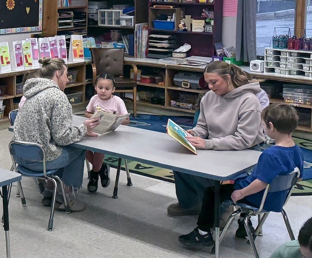 NHS members read to Mrs. Ost and Mrs. Tuss's kindergarten students. 