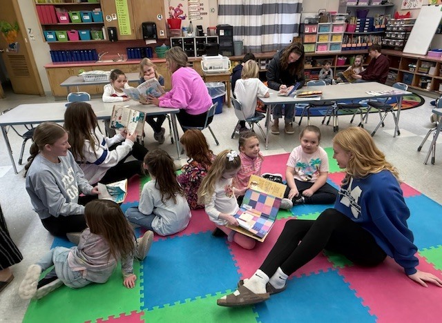 NHS members read to Mrs. Ost and Mrs. Tuss's kindergarten students. 