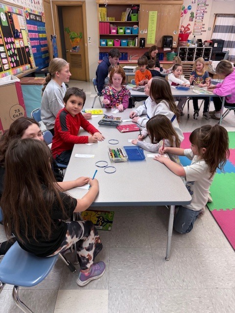 NHS members read to Mrs. Ost and Mrs. Tuss's kindergarten students. 