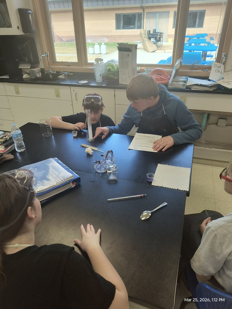 4 students testing the solubility of their substance in a graduated cylinder.