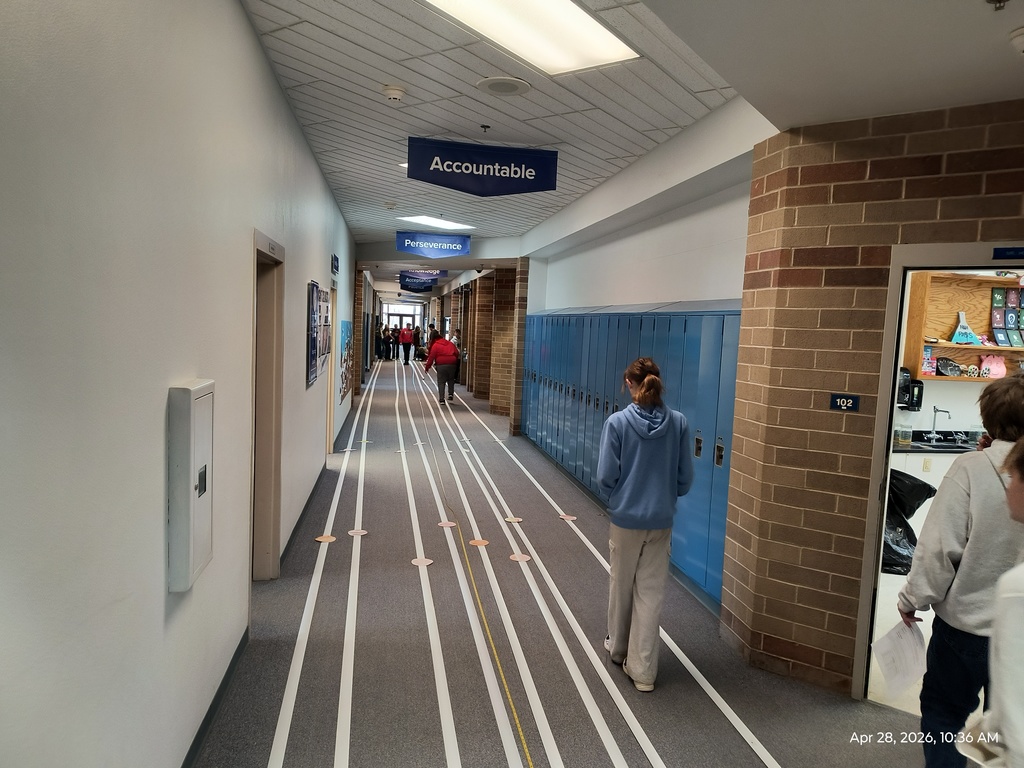 Students working on scale models of the solar system in the school hallway and measuring out accurate distances of their planets.
