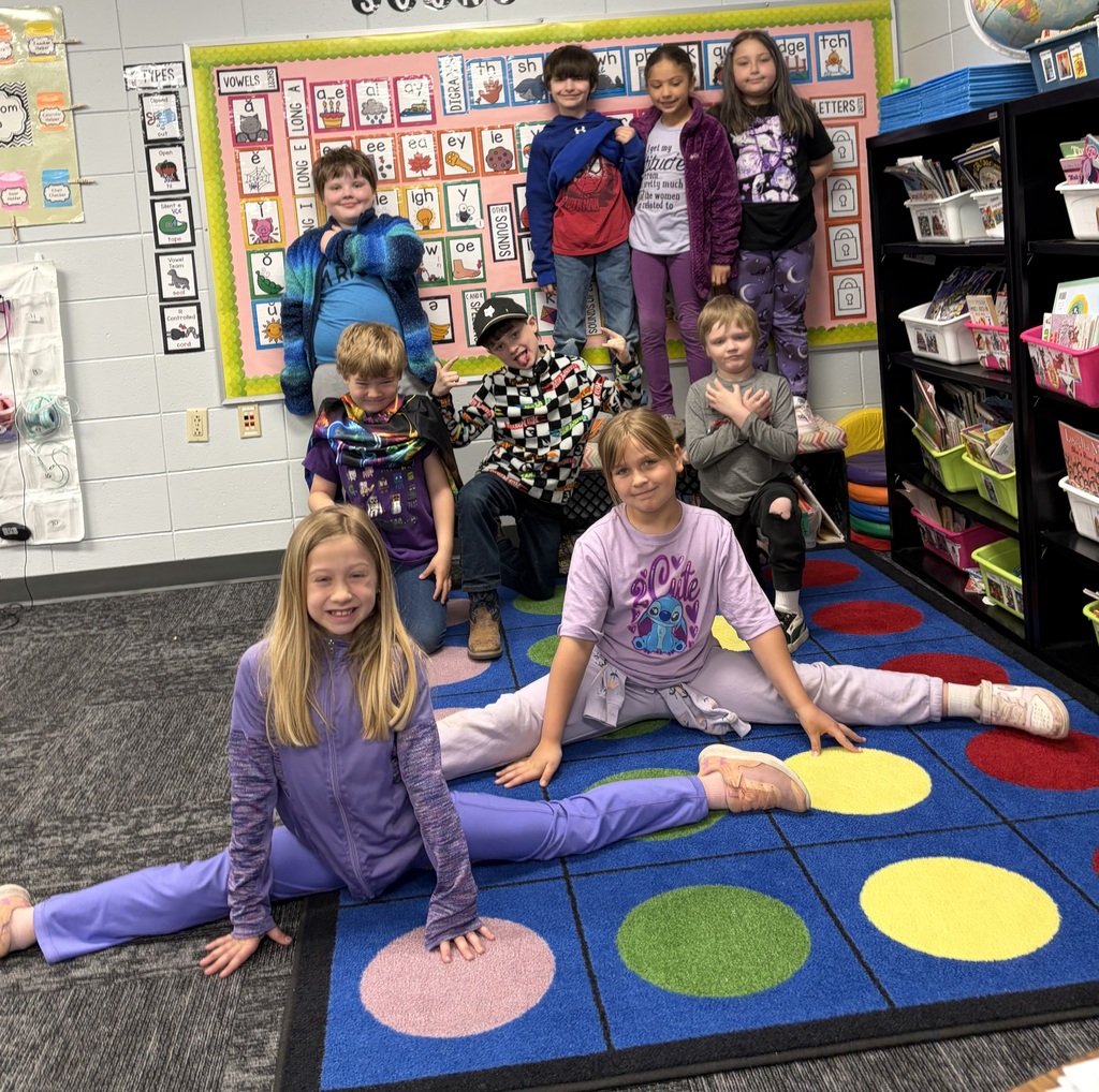 2nd grade students wearing purple for purple day picture in the classroom