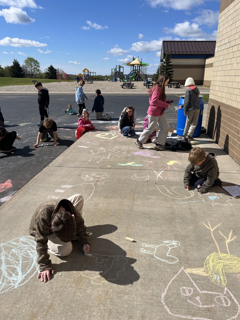 4th grade and kindergarten students outside playing with chalk on the cement
