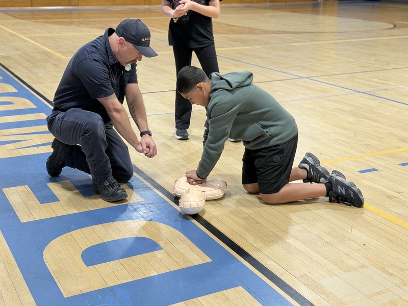 Student learns hands only CPR