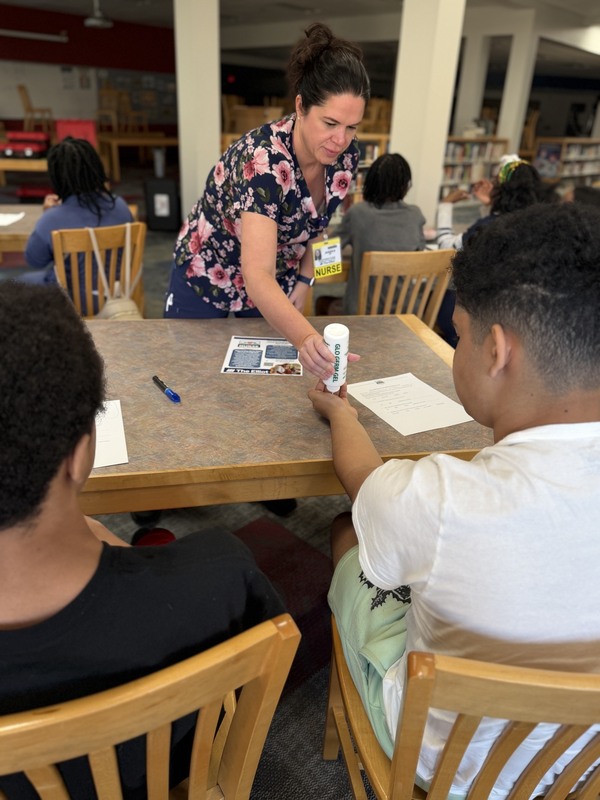 Students in 21st Century program get glow gel on their hands for hand washing demonstration