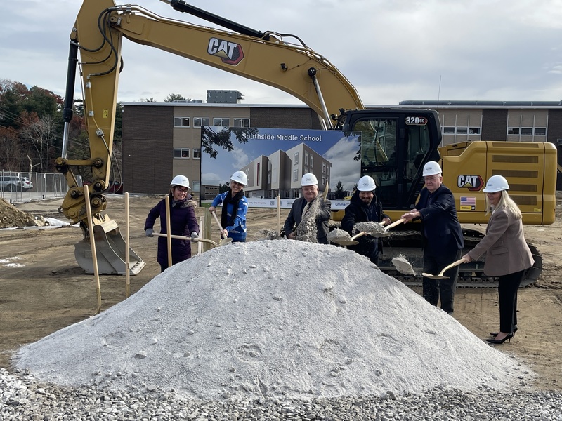 MSD superintendent Dr. Chmiel and board of school members take part in a ceremonial ground breaking at Southside Middle School in front of a yellow piece of construction equipment