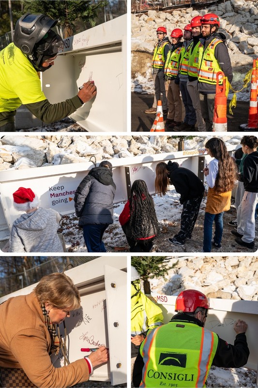 Students district and construction crews sign beam at hillside