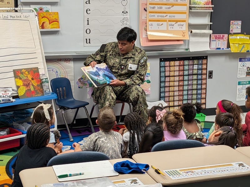 A JB-MDL Reading Buddy shares a story with students from MTES