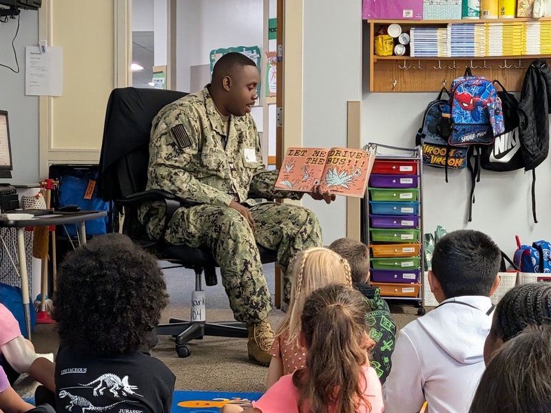 A JB-MDL Reading Buddy shares a story with students from MTES