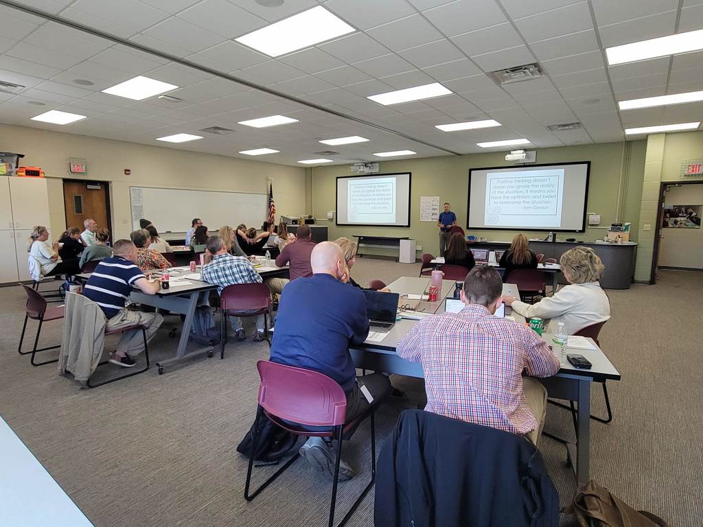 Administrators sitting in groups with Steve presenting at front of room