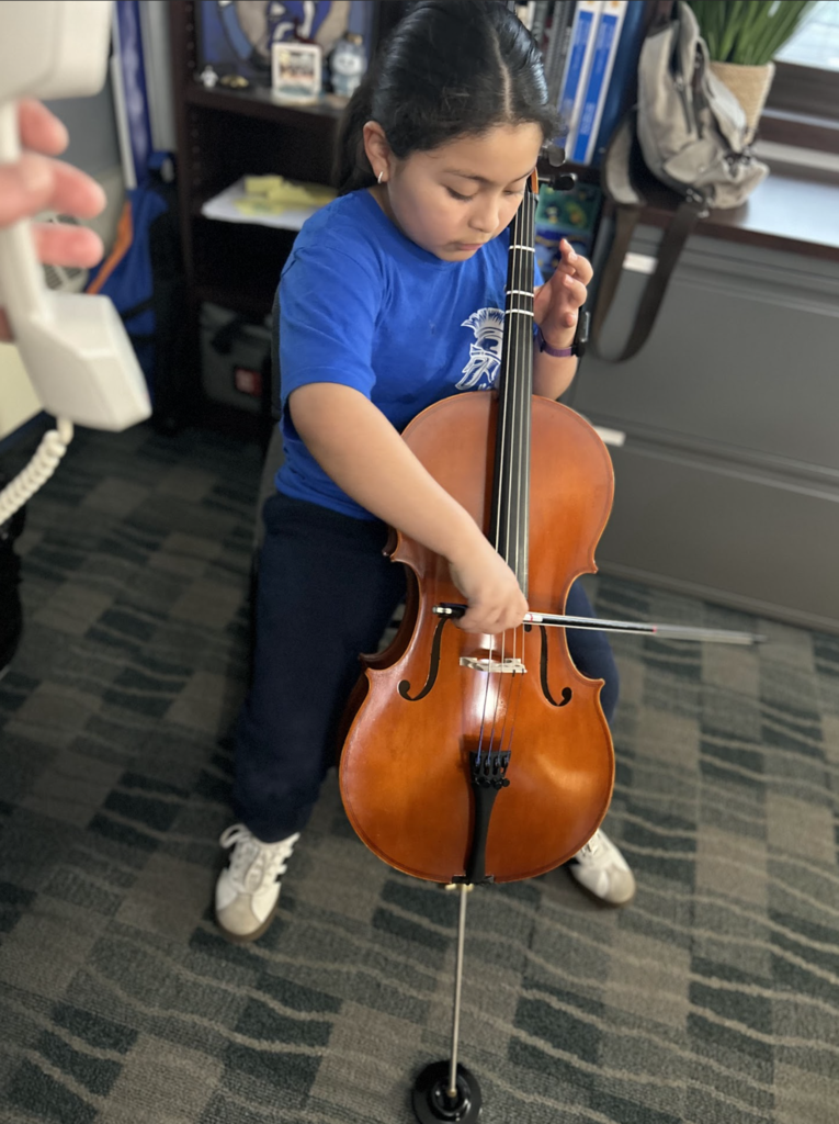 A 3rd grade student playing the cello.