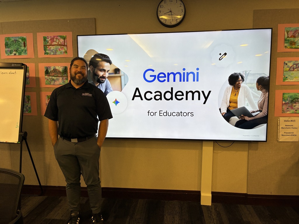 A smiling presenter stands next to a large digital screen displaying the text "Gemini Academy for Educators." The presenter wears a black polo with a subtle "Google" logo. In the background, there is child-drawn art on the wall.