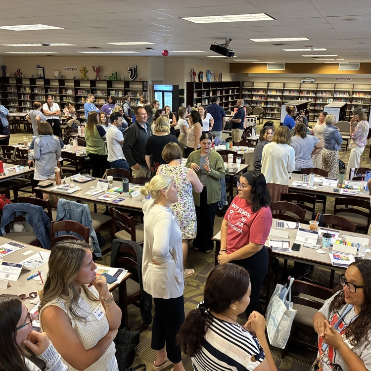 teachers standing in a library discussing social emotional intelligence
