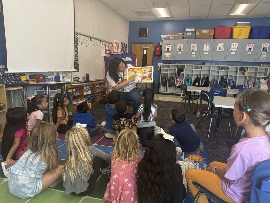 CIS employee reading to elementary students.