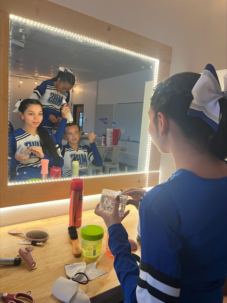Cheerleaders applying makeup.