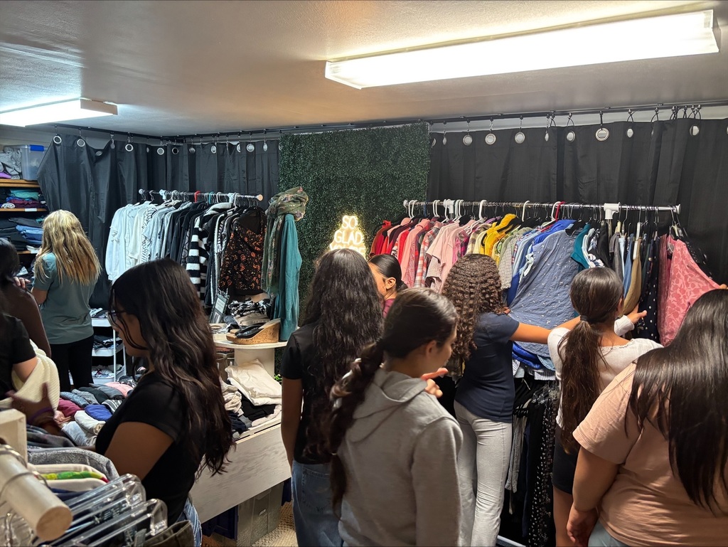 Girls looking through racks of clothing.