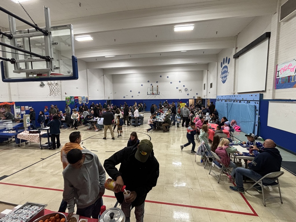 Dads having donuts with their kids in the gym.
