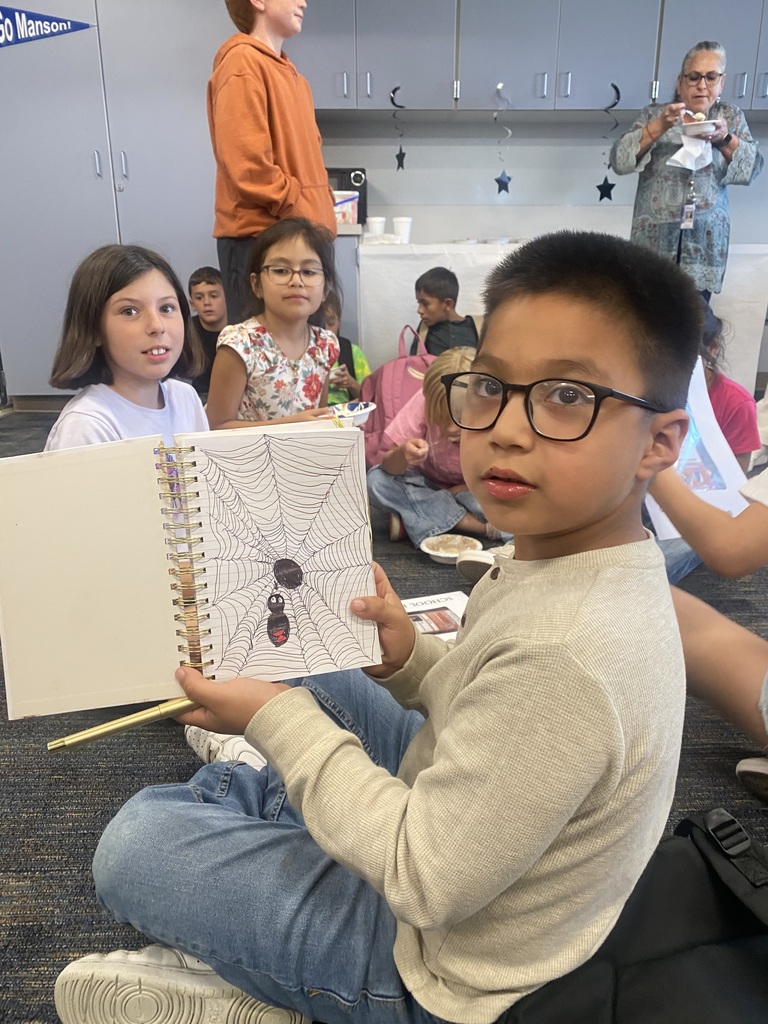 Boy shows off his drawing of a spider.