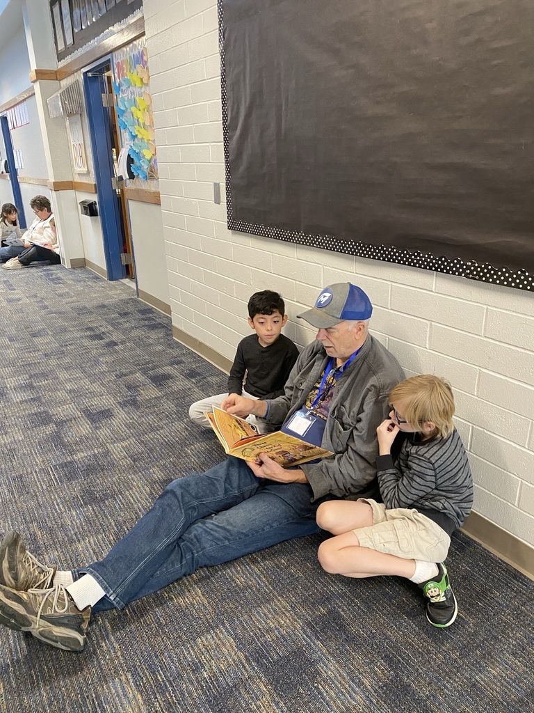 Reading buddies read in the hall.