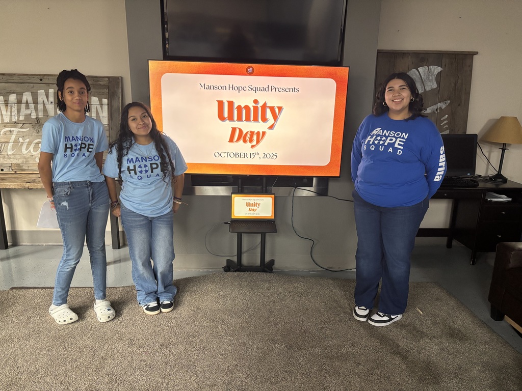 Students stand next to a Unity Day presentation.