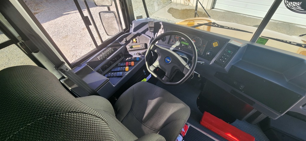 View of bus driver's seat and dashboard.