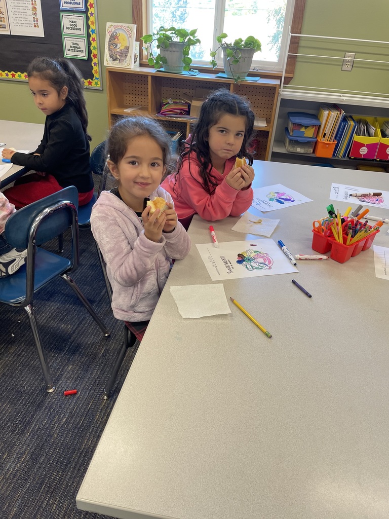 Three girls enjoy Pan de Muerto.