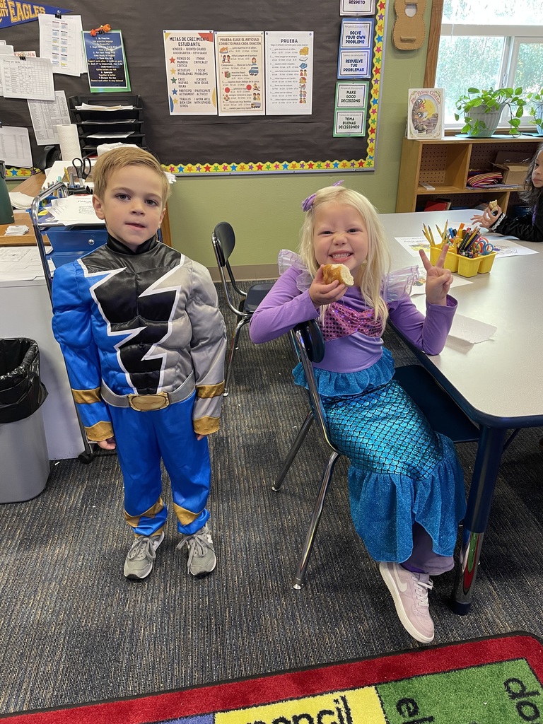 Two students enjoy pan de muerto in their Halloween costumes.
