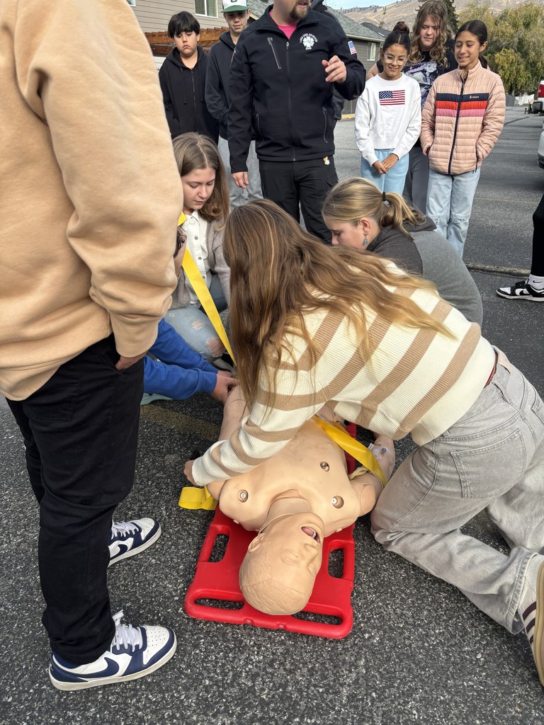 Students strap a dummy patient to a backboard.