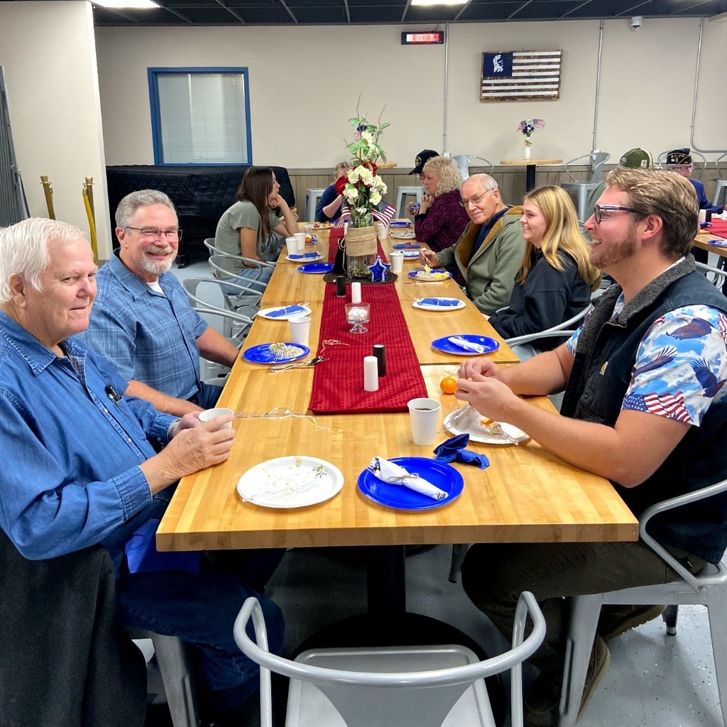 A table full of veterans enjoy breakfast.