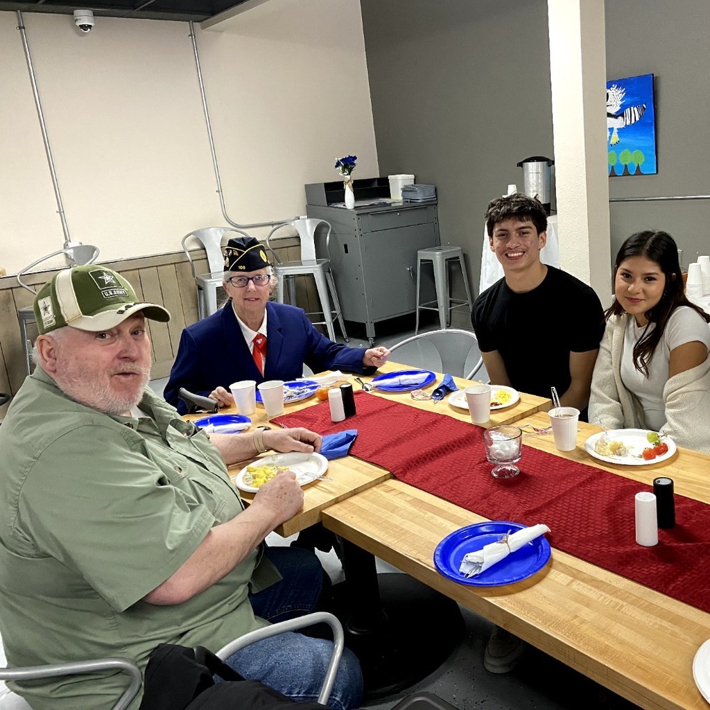 Students share a meal with veterans.