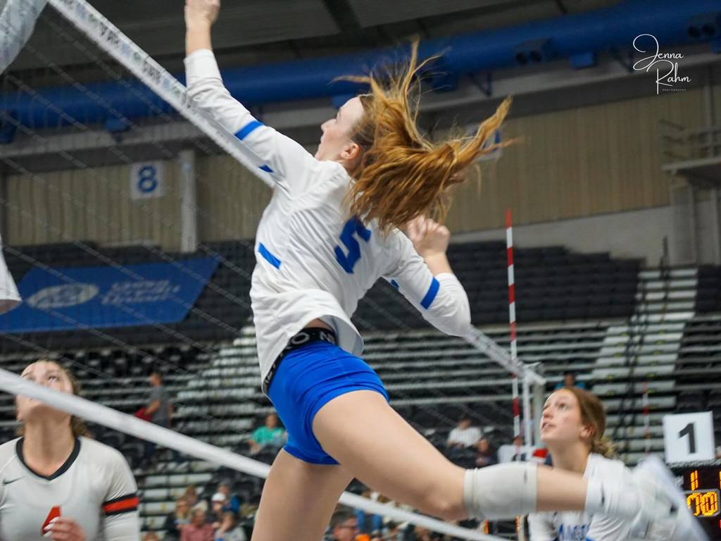 Phinley Teague spikes ball over the net at state tournament.